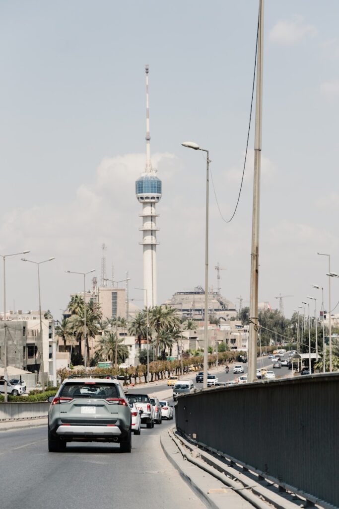 a car driving down a street with a tower in the background