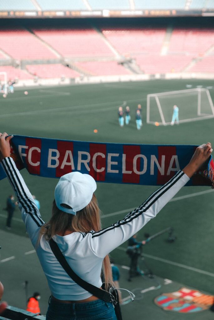 a woman holding up a scarf at a soccer game