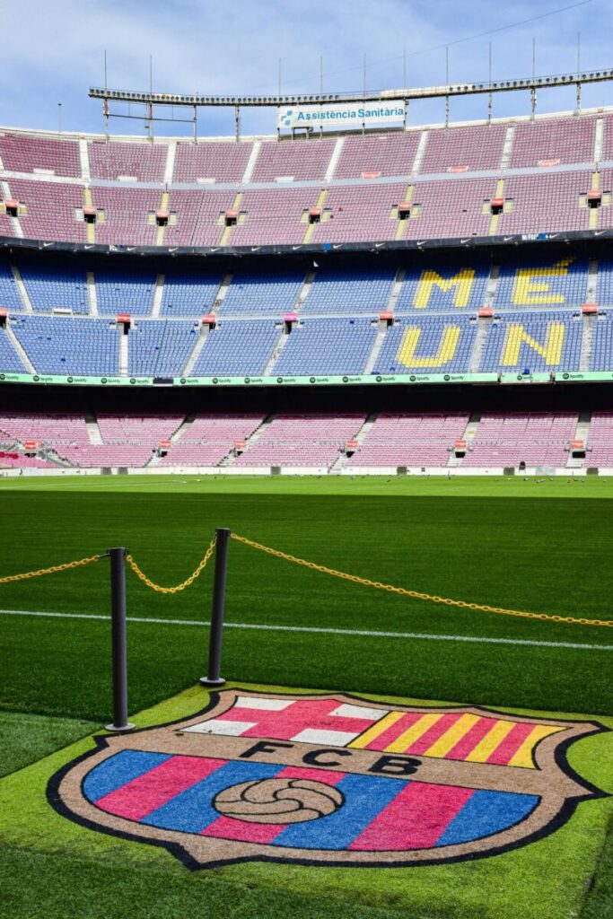 A clear daytime view of Camp Nou Stadium in Barcelona with iconic FCB logo on the field.
