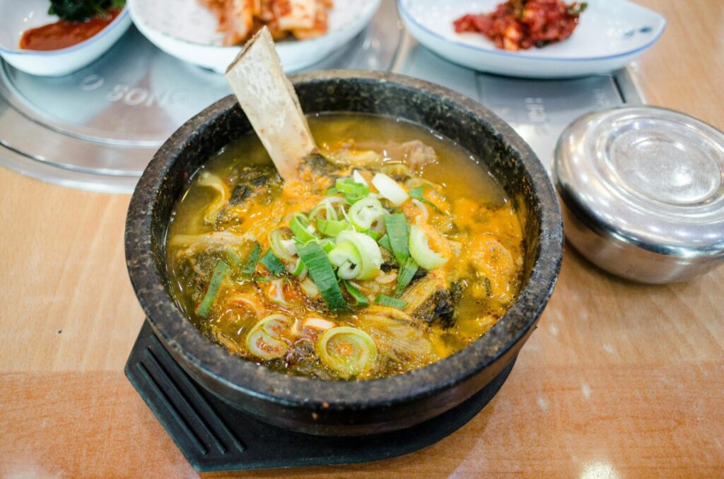 Delicious Korean soup served hot in a traditional stone pot with fresh ingredients.